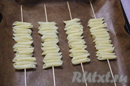 Противень застелить тефлоновым ковриком (или пергаментной бумагой), затем выложить макароны на шпажках.