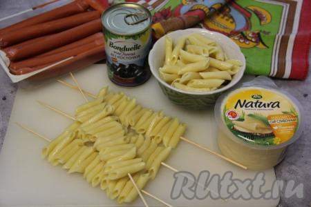 Подготовить продукты. Макароны выложить в кастрюлю с кипящей подсоленной водой и сварить до готовности (обычно на отваривание макаронных изделий требуется минут 7-9, точное время варки указано на упаковке макарон). Важно не переварить макароны, они должны хорошо держать форму после варки. Отваренные макароны сразу откинуть на дуршлаг, чтобы стекла вода, промыть их холодной водой и оставить, чтобы ушла лишняя вода. Для этого блюда можно использовать и макароны, оставшиеся с ужина. Насадить макароны на шпажки. Я на каждую шпажку нанизывала по 15-16 макаронинок. Всего у меня получилось 6 шпажек с макаронами.