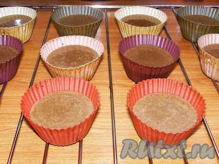 Я запекала маффины в специальных силиконовых формочках и не смазывала их маслом. Если будете готовить в железных формочках, то обязательно смажьте их маслом. Силиконовые формочки ставим на решётку. Вливаем в формочки шоколадное тесто, заполняя формочки, примерно, на 2/3 объёма. У меня получилось 12 формочек с тестом. Советую не заполнять формочки до верха, так как во время выпекания тесто будет подниматься и может вытечь. Ставим решётку с формочками в заранее прогретую до 180 градусов духовку и выпекаем шоколадные маффины, примерно, 30 минут.