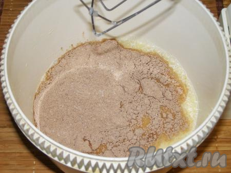 Постепенно, не переставая взбивать, всыпаем сухую смесь из муки, какао-порошка и сахара в чашу миксера. Взбиваем получившееся тесто для кексов минут 10, пока сахар полностью не растворится. По консистенции тесто должно получиться, как сгущённое молоко.