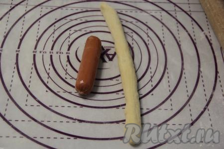 Каждую часть теста скрутить в жгутик. Сосиски очистить от плёнки.