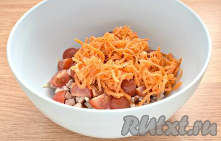 Морковку по-корейски отжимаем от маринада. Очень длинные полоски можно разрезать на 2-3 части. Добавляем корейскую морковь в салат из помидоров, копчёной курицы и сыра.