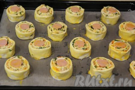 Яичный желток слегка взбить вилкой. С помощью кулинарной кисти смазать слоечки желтком.