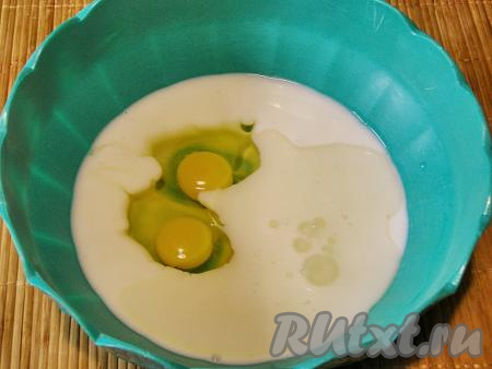 В глубокую миску переливаем кефир, вбиваем яйца и добавляем 2 столовые ложки подсолнечного масла без запаха, перемешиваем кефирно-яичную смесь венчиком до однородности.