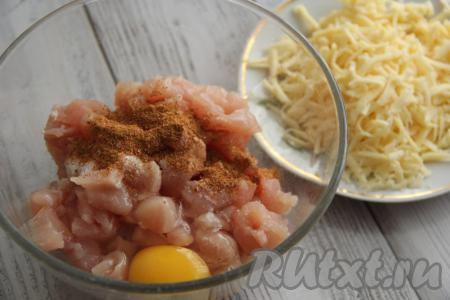 К кусочкам куриного мяса добавить соль, яйцо и специи.