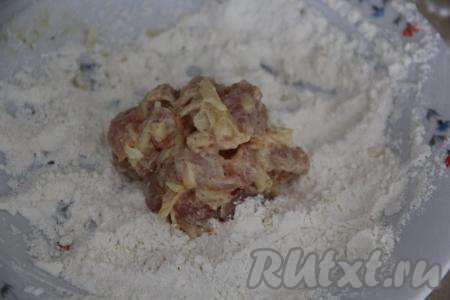 В сковороду влить масло и разогреть. Примерно, по 80-90 грамм курино-сырной массы столовой ложкой выкладывать в тарелку с мукой. Обвалять со всех сторон в муке, формируя котлету.