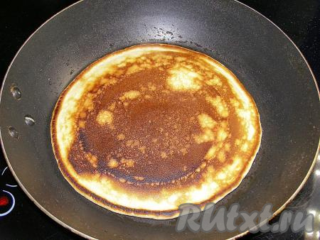 С помощью лопаточки переворачиваем блин на другую сторону и жарим ещё около 2 минут, затем перекладываем на тарелку. Перед тем как влить на сковородку очередную порцию теста, слегка смазываем её маслом. Для этого я использую кусочек сырой очищенной картошки, которую обмакиваю в масло. Постепенно пожарить все блинчики, складывая их один на другой на тарелку (у меня получилось 9 блинов).