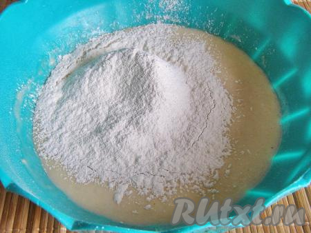 Просеиваем в опару немного муки и перемешиваем тесто ложкой. Постепенно всыпаем оставшуюся муку и замешиваем тесто руками.