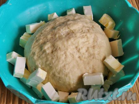 Добавляем в тесто кусочки сливочного масла комнатной температуры. Вмешиваем масло в тесто руками.