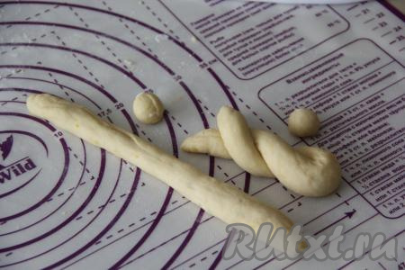 Подошедшее тесто нужно обмять, затем переложить на силиконовый коврик (или на припылённый мукой стол). Разделить тесто на 10 частей. Каждую часть раскатать в длинный жгутик. От жгутика теста отщипнуть маленький кусочек - это будет "хвостик", скатать в шарик. Оставшуюся часть жгутика сложить пополам и свернуть в виде спирали, как на фото. 