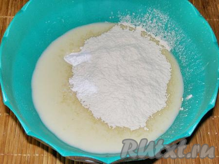 В получившуюся смесь всыпаем часть просеянной муки, добавляем разрыхлитель и соду. По желанию, можно добавить одну щепотку ванилина. Очень хорошо перемешиваем тесто венчиком.
