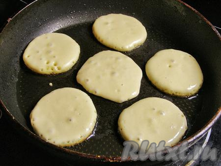 В сковородке на сильном огне разогреваем подсолнечное масло. В горячее масло, не перемешивая, столовой ложкой выкладываем тесто. Жарим на среднем огне, примерно, 2 минуты (до подрумянивания оладушек с нижней стороны).