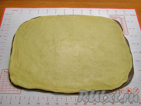 Также тонко в пласт такого же размера раскатываем светлое тесто. Кладём его сверху на шоколадное тесто.