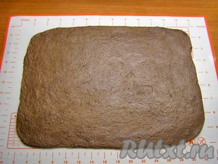 Шоколадное тесто на слегка присыпанной мукой поверхности раскатываем в прямоугольник размером, примерно, 22 сантиметра на 28 сантиметров и толщиной около 3 миллиметров.