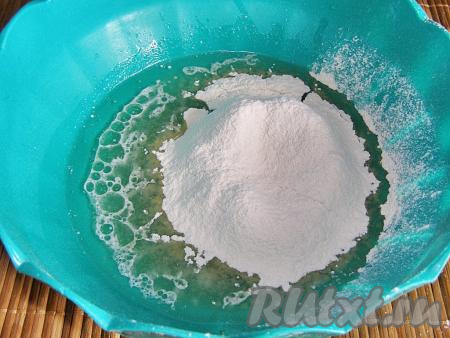 Постепенно всыпаем в сыворотку муку, каждый раз хорошо перемешивая ложкой (или венчиком). Когда тесто станет достаточно плотным, продолжаем перемешивать его руками. Вам может понадобиться немного меньше или больше того количества муки, которое указано в рецепте, главное - ориентироваться на консистенцию замешиваемого теста.