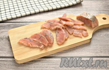 Солёную красную рыбу нарезаем ломтиками.