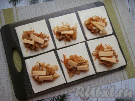 В середину каждого квадрата выложить по 1-2 столовых ложки капусты. По желанию, к капустной начинке можно добавить по два кусочка твёрдого сыра.