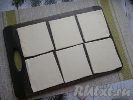 На присыпанной мукой поверхности немного раскатать слоёное тесто. Разрезать пласт теста на 6 квадратов.