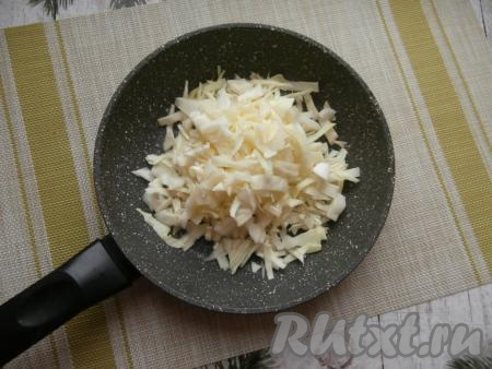 При комнатной температуре разморозить слоёное дрожжевое тесто. Лук и половину морковки очистить. Капусту достаточно тонко нарезать, поместить в сковороду с растительным маслом.