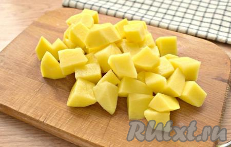 Половину луковицы, картошку и морковку очищаем. Картошины нарезаем на небольшие кубики, перекладываем в бульон, после закипания варим 5 минут на небольшом огне.