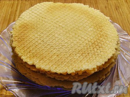 Готовую вафлю с помощью лопаточки перекладываем на плоскую тарелку. Постепенно&nbsp; выпекаем все вафли, складывая их одна на другую на тарелку. Из данного количества теста получается 18-20 вафель. Даём вафлям остыть.