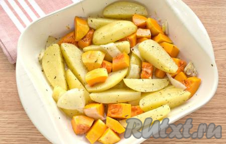 Форму с картошкой достаём из духовки, добавляем кусочки тыквы и мелко нарезанный зубчик чеснока, перемешиваем.