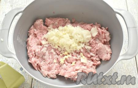 Фарш можно взять и покупной, и приготовленный в домашних условиях. Я предпочитаю готовить фарш самостоятельно, пропуская через мясорубку кусочки мяса (в этот раз я сделала фарш из свинины и говядины). В миску перекладываем мясной фарш. Половину очищенной луковицы мелко нарезаем и вместе с пропущенным через пресс чесноком добавляем к фаршу.