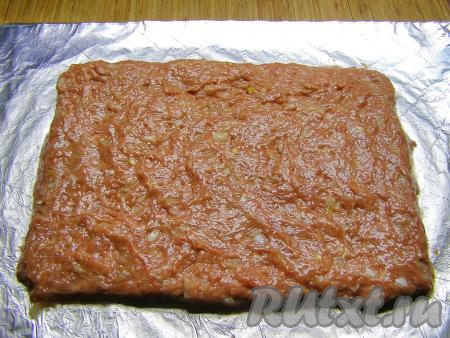 Стол (или разделочную доску) застилаем фольгой, слегка смазываем её растительным маслом и равномерно выкладываем фарш в форме прямоугольника размером, примерно, 20 см на 15 см и толщиной 5-7 мм.