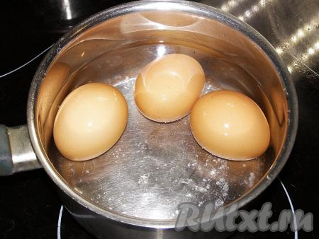 Сначала отварим 3 яйца, которые станут начинкой для рулета, для этого их моем, перекладываем в сотейник (или небольшую кастрюльку), заливаем полностью холодной водой, ставим на огонь и после закипания варим 8-10 минут. Затем охлаждаем яйца под холодной водой и очищаем от скорлупы.