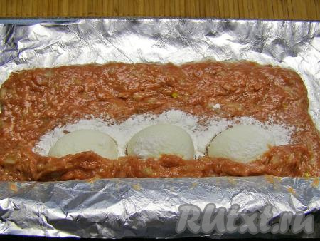 Помогая фольгой, накрываем яйца фаршем сначала с одной стороны, затем - с другой. Формируем подобие колбаски с начинкой из варёных яиц.