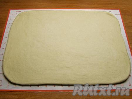 Поверхность слегка припыляем мукой и раскатываем тесто в прямоугольник размером, приблизительно, 30 сантиметров на 35 сантиметров и толщиной около 5 миллиметров.