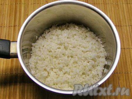 Рис промываем несколько раз. В достаточно большое количество кипящей, слегка подсоленной воды выкладываем промытый рис, даём закипеть воде, а затем&nbsp; отвариваем рис до полуготовности (на это потребуется минут 8-10), затем сливаем воду через дуршлаг. Оставляем рис остывать. Промывать отваренный рис не надо, иначе он потеряет клейкость и тефтели могут развалиться.