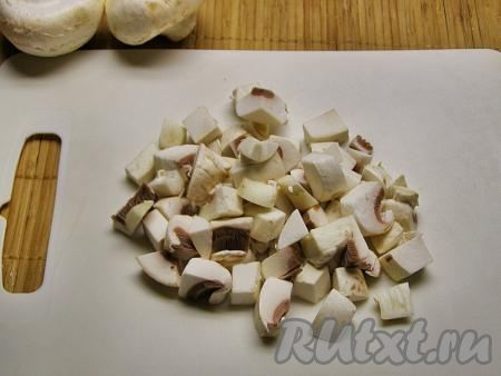 Если вы используете лесные грибы, их нужно перебрать, промыть, залить свежей водой и отварить с момента закипания в течение минут 30, затем лишнюю воду слить, переложив в дуршлаг, а после этого крупные грибочки нарезать на небольшие кусочки. Свежие шампиньоны (или вешенки) нужно промыть, обсушить бумажными салфетками и нарезать на средние кубики. Замороженные грибы нужно разморозить, при необходимости, разрезать на несколько частей. С консервированных грибов нужно слить жидкость, если необходимо, нарезать на части.