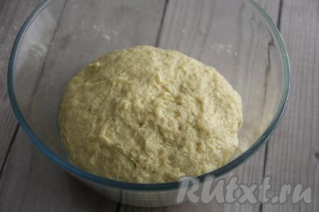 Как только тесто начнёт собираться в комок, начать вымешивать его руками, продолжая добавлять оставшуюся муку. Муки может понадобится больше или меньше указанного количества. Главное - ориентироваться на консистенцию замешиваемого теста для кулича. Вымешивать тесто нужно 7-10 минут. Тесто должно получиться эластичным, мягким и нежным. Выложить тесто в миску, предварительно смазанную маслом, и накрыть полотенцем.