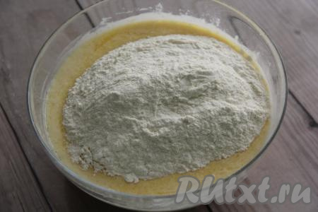 Всыпать соль и начать всыпать частями просеянную муку, перемешивая ложкой.