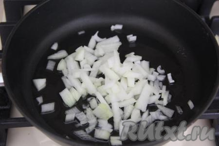 Влить в сковороду растительное масло, выложить мелко нарезанную луковицу и обжаривать до золотистости, иногда перемешивая, на среднем огне.