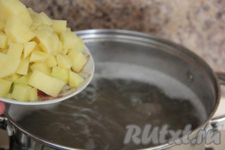 По прошествии часа, по желанию, бульон можно процедить. Крылышки вернуть в кастрюлю. Довести бульон с утиными крыльями до кипения. Картошины очистить, нарезать на средние кубики, а затем выложить в кипящий бульон. Снова дать бульону закипеть и, уменьшив огонь, варить картошку 10 минут.​​​