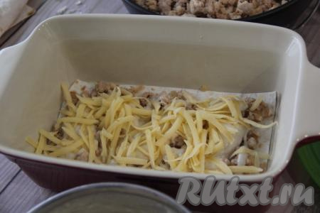 Сыр натереть на тёрке и выложить часть сыра.