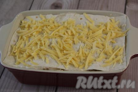Накрыть начинку листом лаваша и слегка прижать. Таким образом собрать всю лазанью. Верхний слой&nbsp; лаваша присыпать только натёртым сыром.