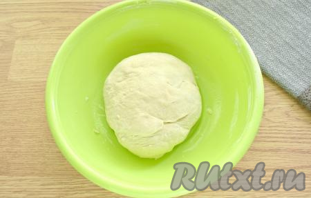 Замешиваем тесто. Сначала ингредиенты смешиваем ложкой в миске, а потом продолжаем замес дрожжевого теста уже на столе. В процессе замешивания добавляем оставшуюся часть муки. Месим тесто для пышек не менее 10 минут на столе. Тесто должно получиться мягким, эластичным. Не нужно забивать тесто мукой. Получившееся тесто перекладываем в миску, затем прикрываем полотенцем и ставим в тёплое место, примерно, на час (или чуть больше). Тесто должно увеличиться в объёме раза в 2.