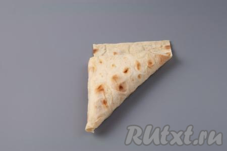 Оставшийся край лаваша обрежьте или подверните внутрь треугольника. Таким образом сформируйте все пирожки из лаваша с капустой. У меня получилось 14 штук.