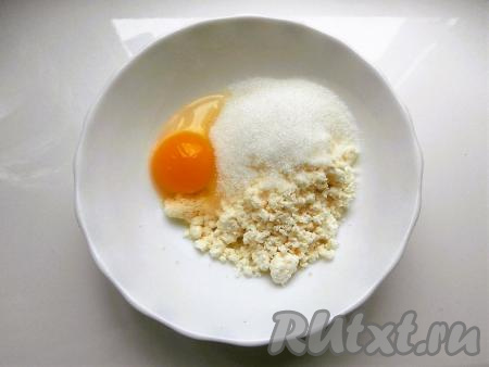 Творог переложить в достаточно объёмную ёмкость, добавить сахар, ванилин и яйцо.