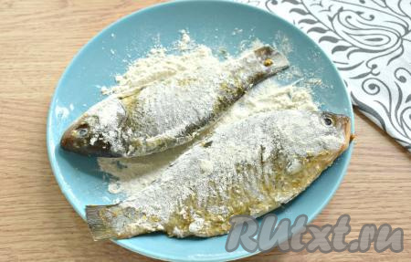 На тарелку насыпаем муку. Обваливаем карасей с каждой стороны в муке.