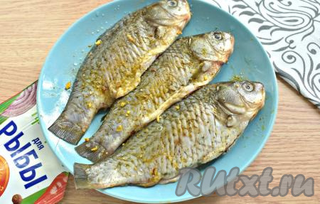 Натираем карасей со всех сторон солью, приправой для рыбы и молотым чёрным перцем.