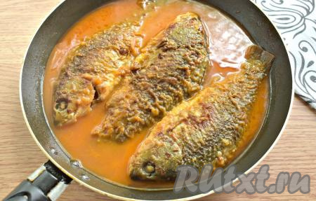 Убавляем нагрев плиты до минимального, сковороду накрываем крышкой. Тушим карасей в томатном соусе 10 минут.
