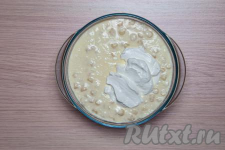 Смажьте сливочным маслом форму для запекания. Выложите туда творожно-макаронную смесь.&nbsp;Поверхность запеканки смажьте сметаной и разровняйте лопаткой.