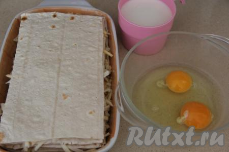 Накрыть следующим отрезанным листом лаваша, смазать майонезом, присыпать частью сыра, накрыть следующим отрезанным листом лаваша. Таким образом, чередуя, собрать весь пирог, пока не закончится сыр. Верхним слоем должен быть лаваш.