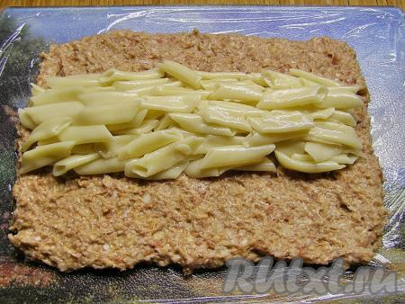 В середину прямоугольника из фарша выкладываем остывшие макароны.