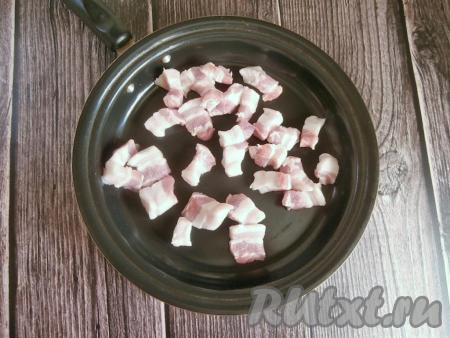 Картофель и лук очистить. Нарезать картошку на небольшие кусочки. Свиную грудинку тоже нарезать на небольшие кусочки, затем поместить в сковороду.