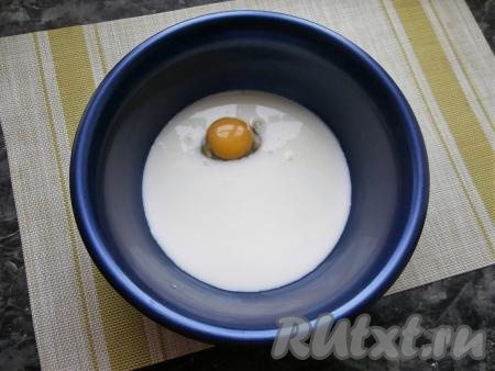 Влить молоко комнатной температуры в миску, добавить соль и сырое яйцо.